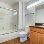 Bathroom with single sink vanity and a tub/shower combo with sliding door