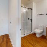 Bathroom with modern fixtures, walk-in shower, towel racks and hook, and sliding glass shower doors