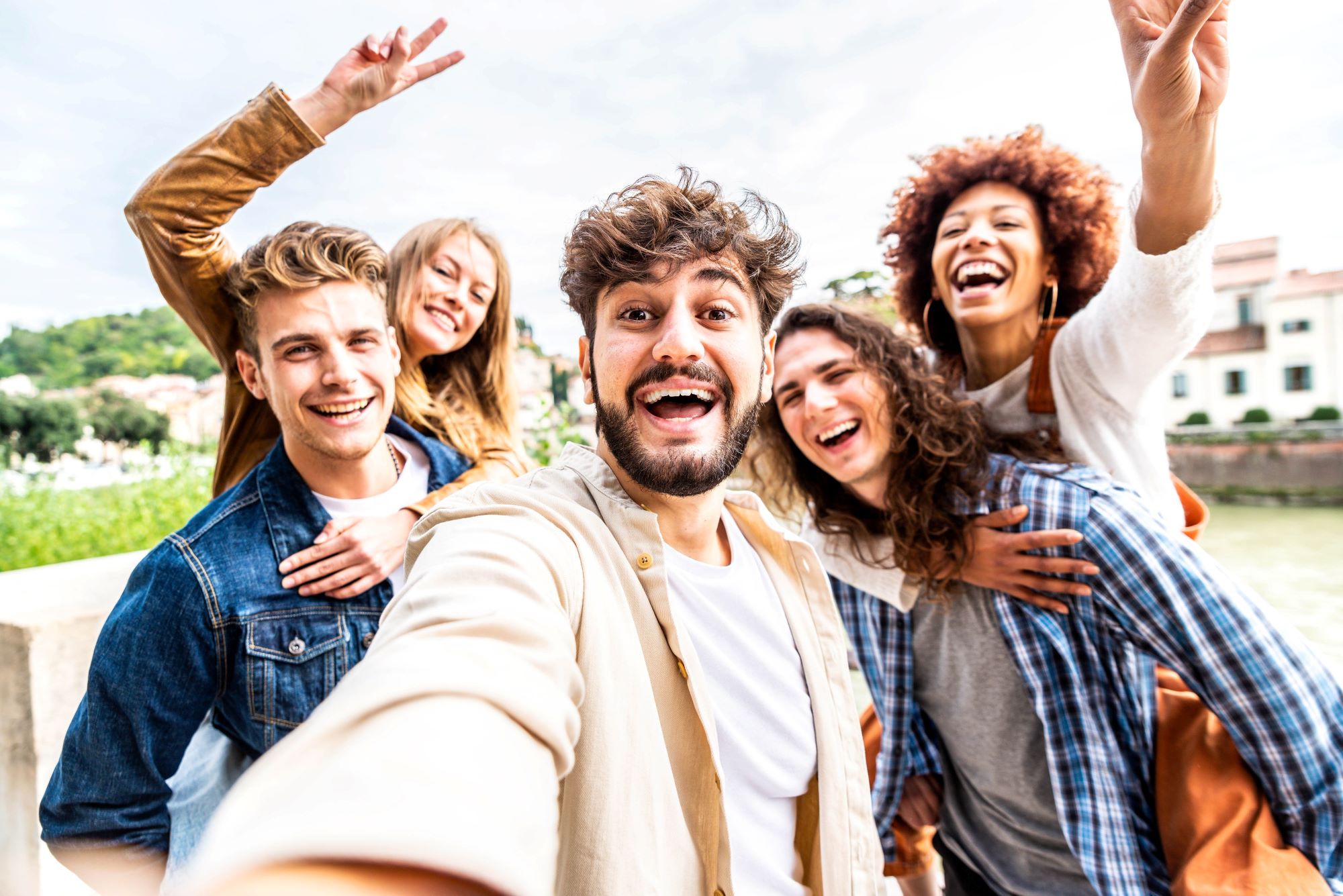 Group of friends taking a selfie outside and laughing