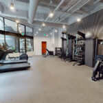 Allston Place fitness center with weight benches, free weights, kettlebells, medicine balls, and treadmills